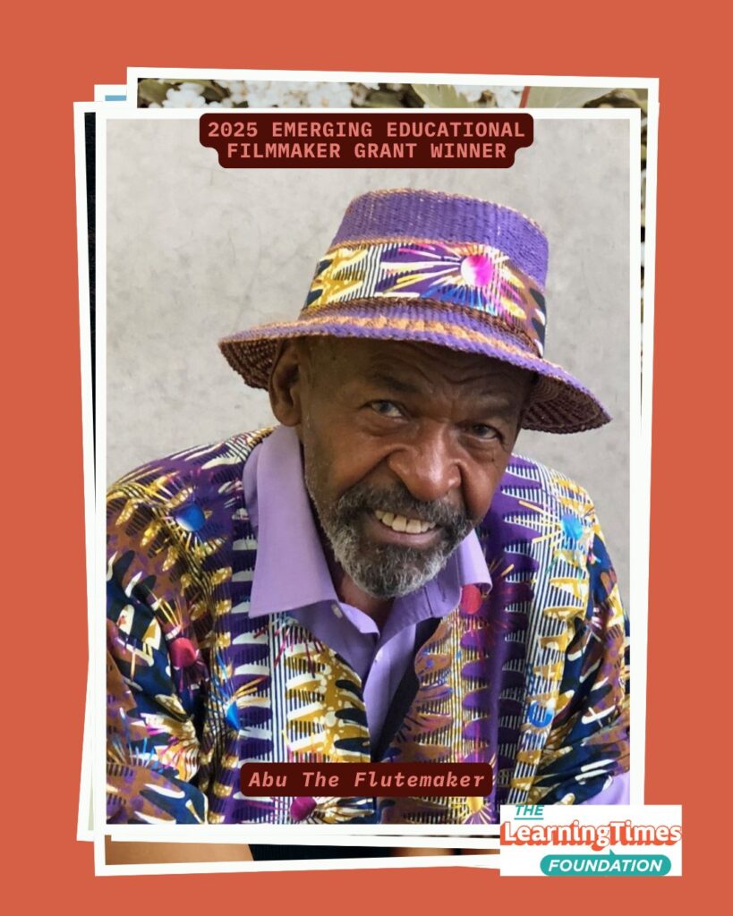 Portrait photograph of Abu The Flutemaker smiling warmly at the camera, wearing vibrant traditional African-style clothing. Abu wears a purple bucket hat decorated with bold geometric patterns in purple, yellow, and blue, and a matching outfit featuring intricate African print patterns in purple, yellow, blue, and other colors over a lavender collared shirt. He has a gray beard and a welcoming smile. A decorative strip of white blossoms appears at the top of the frame. The image is set on an orange background with white frame borders. Text at the top reads '2025 EMERGING EDUCATIONAL FILMMAKER GRANT WINNER' in orange, with 'Abu The Flutemaker' labeled at the bottom. The Learning Times Foundation logo appears in the bottom right corner.